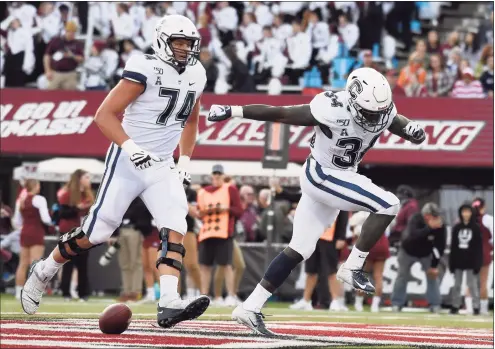  ?? Jessica Hill / Associated Press ?? UConn running back Kevin Mensah (34) celebrates his touchdown with Ryan Van Demark (74) against UMass on Oct. 26, 2019, in Amherst, Mass.