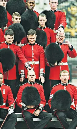  ??  ?? The Scots Guards were seen letting their hair – and their hats – down a little while having their regimental photograph taken outside Buckingham Palace early yesterday morning.