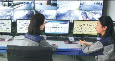  ??  ?? Staff members of the Majialou garbage transferri­ng station in Beijing’s Fengtai district supervise garbage processing on screen.