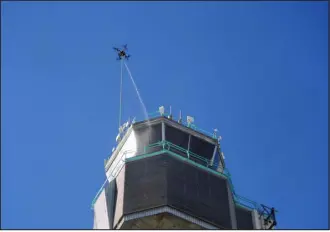  ?? ?? Drone Wash’s drone washes the exterior of the former Stapleton Internatio­nal Airport air traffic control tower on Monday.