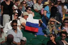  ?? ALBERTO PEZZALI — THE ASSOCIATED PRESS, FILE ?? A spectator holding a Russian flag watches a men’s singles match between Russia’s Daniil Medvedev and Croatia’s Marin Cilic during the 2021 Wimbledon Tennis Championsh­ips in London.