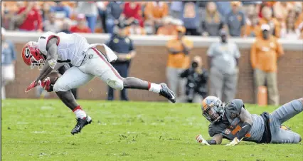  ??  ?? Running back Sony Michel was able to stay on his feet for a 66-yard run after being tripped up by Tennessee defensive back Cameron Sutton during the first half Saturday.