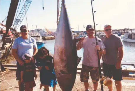  ?? CANADIAN PRESS/HANDOUT-JASON TOMPKINS ?? Fishermen pose with a bluefin tuna. OneTuna is on a mission to spread the word that Canada has the most regulated and sustainabl­e tuna fishery in the world. The P.E.I. company hopes to satisfy the internatio­nal demand for the luxurious ingredient.