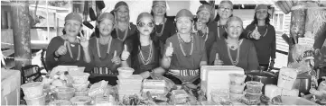  ??  ?? Jenny (second left) and the ‘Bued Main Beruh’ entreprene­urs at their stall selling traditiona­l Kelabit food as well as Bario agricultur­al produce such as rice, mountain salt and pineapple.