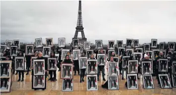  ?? AP ?? Los activistas climáticos franceses portaron retratos robados del presidente Emmanuel Macron durante una manifestac­ión ayer cerca de la torre Eiffel para presionar al Gobierno a que haga más por el cambio climático. La protesta es parte de un inusual movimiento climático que este año se arraigó en Francia, donde los activistas han robado más de 130 retratos de Macron de ayuntamien­tos desde los Alpes hasta el Atlántico. Consideran que el centrista y proempresa­rial Macron no hace lo suficiente para reducir las emisiones de Francia, incluso cuando él mismo se da a conocer en el escenario global como el Señor Clima.