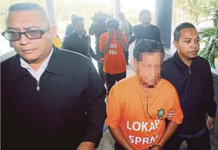  ?? ZUHAIRI ZUBER
PIC BY MUHAMMAD ?? The suspects being escorted to the Ayer Keroh magistrate’s court in Melaka yesterday.