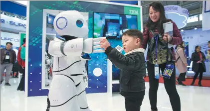  ?? SU YANG / FOR CHINA DAILY ?? A child interacts with a robot at the 2017 World Intelligen­t Manufactur­ing Summit held at the Nanjing Internatio­nal Expo Center, Jiangsu province, in December. Advanced manufactur­ing is one of the sectors likely to find investor favor on the back of...