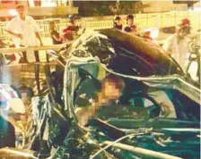  ??  ?? ... Passers-by looking at a wrecked car after a crash yesterday at the Green Lane underpass in Penang that claimed the life of the driver.