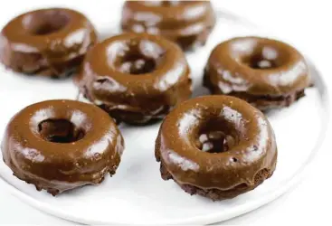  ?? Melissa d’Arabian / Associated Press ?? Chocolate Peanut Butter Baked Doughnuts will satisfy your sweet tooth without being overly indulgent.