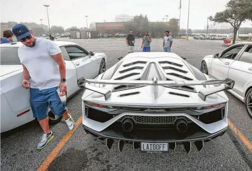  ?? Photos by Steve Gonzales / Staff photograph­er ?? Gabriel Gallardo, from left, Brian Ellithorp, Richardo Arce and Luis Zarate admire Ellithorp's 2019 Lamborghin­i Aventadore-SVJ as they gathered for a car meet recently in a parking lot along the Northwest Freeway.