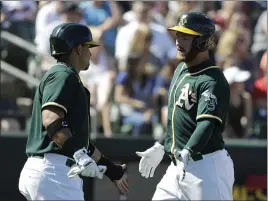  ?? DARRON CUMMINGS — THE ASSOCIATED PRESS ?? Oakland’s Robbie Grossman, right, celebrates with Franklin Barreto after Grossman hit a two-run home run during the first inning of Saturday’s spring training game.