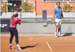  ?? Associated Press ?? ↑
Serena Williams returns the ball as her coach Patrick Mouratoglo­u (right) looks on during a training session in Rome on Monday.