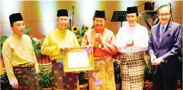  ??  ?? Musa (centre) receiving the Ramsar site certificat­e from Wan Junaidi, witnessed by Hamim (second from right), Masidi (right) and Azizan.