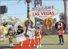  ?? K.M. Cannon Las Vegas Review-journal @Kmcannonph­oto ?? Vegas Golden Knights mascot, Chance, Anthem singer Carnell “Golden Pipes” Johnson and members of the Golden Aces cheer squad walk the red carpet Thursday at the “Welcome to Fabulous Las Vegas” sign to promote the wearing of masks.