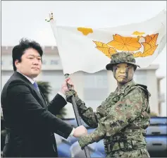  ??  ?? Yamamoto (left) gives a brigade flag to Maj Gen Shinichi Aoki, commander of Japanese Ground Self-Defence Force (JGSDF)’s Amphibious Rapid Deployment Brigade during a ceremony activating the brigade at JGSDF’s Camp Ainoura in Sasebo, on the southwest...