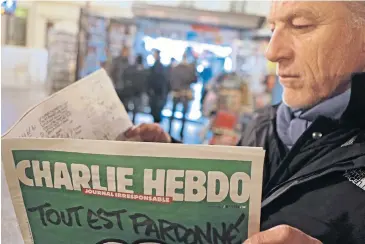  ?? AP ?? Jean Paul Bierlein reads the new “Charlie Hebdo” in Nice, southeaste­rn France, yesterday. In an emotional act of defiance, “Charlie Hebdo” resurrecte­d its irreverent and often provocativ­e newspaper, featuring a caricature of the Prophet Mohammed on the...