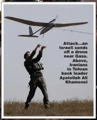  ?? ?? Attack...an Israeli sends off a drone near Gaza. Above, Iranians in Tehran back leader Ayatollah Ali Khamenei