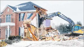  ?? COLIN CHISHOLM/HANTS JOURNAL ?? Pieces of the home on Mountain View Drive in Falmouth fall away from the structure as the excavator demolishes the building Tuesday.