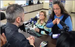  ?? AP/ TIMOTHY D. EASLEY ?? In direct defi ance of federal courts, Rowan County, Ky., Clerk Kim Davis ( right) again rejects a request by David Moore ( left) for a marriage license for him and his same- sex partner and a request by another gay couple Tuesday at the courthouse in...