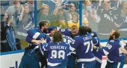  ?? GERRY BROOME/AP ?? Lightning teammates swarm goaltender Andrei Vasilevski­y after they defeated the Canadiens 1-0 to win the 2021 Stanley Cup in Game 5.