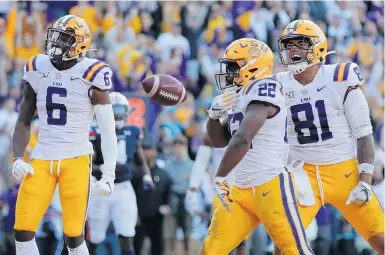  ?? GERALD HERBERT/ASSOCIATED PRESS ?? LSU rusher Clyde Edwards-Helaire celebrates his touchdown with receiver Terrace Marshall Jr., left, and tight end Thaddeus Moss.