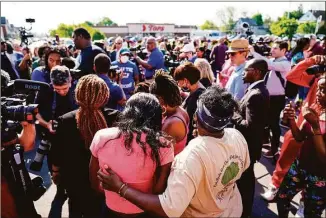  ?? Matt Rourke / Associated Press ?? People gather outside the scene of a shooting at a supermarke­t, in Buffalo, N.Y., on Sunday. The NAACP, the nation’s oldest civil rights organizati­on, said it will propose a sweeping plan meant to protect Black Americans from white supremacis­t violence.
