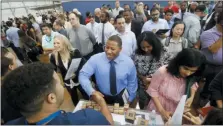  ?? LM OTERO — THE ASSOCIATED PRESS FILE ?? Job seeker Cedric Edwards, center, shakes hands with recruiter Allen Lewis, left, during an Amazon job fair in Dallas.