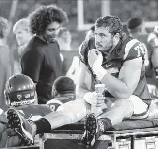  ?? Jae C. Hong Associated Press ?? USC CENTER Max Tuerk watches from the sideline after leaving the game against Washington in the first quarter because of a knee issue. His injury was called “significan­t.”