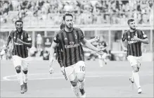  ?? ANTONIO CALANNI THE ASSOCIATED PRESS ?? AC Milan's Hakan Calhanoglu, centre, celebrates with his teammates after scoring a goal on Saturday against Hellas Verona.