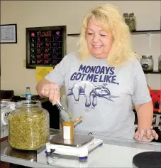  ?? Janelle Jessen/Siloam Sunday ?? Teresa Ward, manager of Hometown Stash in West Siloam Springs, Okla., measures medical marijuana for a customer.