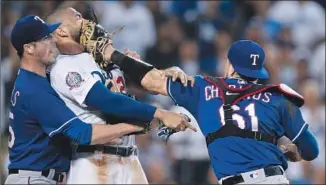  ?? Jae C. Hong Associated Press ?? TEXAS PITCHER Cole Hamels restrains the Dodgers’ Matt Kemp as Kemp scuff les with Rangers catcher Robinson Chirinos following a home plate collision. Kemp and Chirinos were ejected.