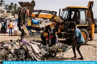  ?? ?? DAKAR, Senegal: Men pile waste collected from the beach during a beach clean up along Hann Bay in Dakar on November 11, 2023. — AFP