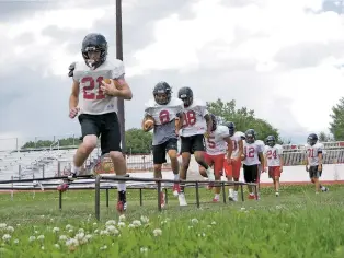  ?? MATT DAHLSEID/THE NEW MEXICAN ?? Robertson players run through a high-step agility drill Thursday during practice. The Cardinals hope to again run the ball well to set up their passing game.