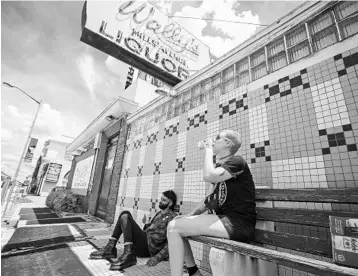  ?? JACOB LANGSTON/STAFF PHOTOGRAPH­ER ?? Chris Hymer, left, and Nichole Reno were among several who paid their respects (and drank a beer) outside Wally’s Liquors on Tuesday. A sign on the door of the popular dive bar announced it was shutting down after 64 years.