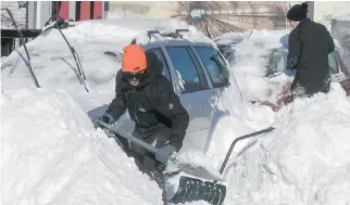  ?? PIERRE OBENDRAUF ?? Julian Gammom, left, and Nicholas Hurtubise have a long way to go to clear their cars from a snowbank on de Maisonneuv­e near Girouard on Sunday.