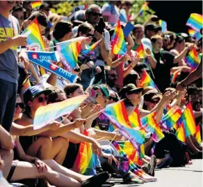  ?? DARRYL DYCK/THE CANADIAN PRESS ?? Spectators wave rainbow flags at Vancouver’s Pride parade on Aug. 4. Ottawa’s Capital Pride Parade is scheduled for Saturday, Aug. 25.