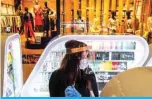  ??  ?? MOSCOW: Mobile phones accessorie­s seller sits at her desk wearing a protective mouth and nose mask and a face shield at the Evropeyski­y shopping mall in Moscow on Tuesday. – AFP