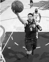  ?? NATHANIEL S. BUTLER/GETTY ?? The Magic’s Nikola Vucevic goes up for a layup during a game against the Knicks on Sunday night in New York.