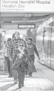  ?? Brett Coomer / Houston Chronicle ?? MetroRail riders walk off the platform in the Texas Medical Center on Friday. Steady growth in the medical sector has kept the city’s economy healthy.