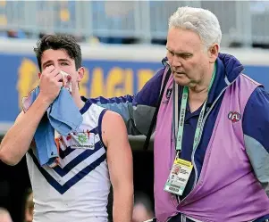  ??  ?? Andrew Brayshaw, of the Dockers, is helped off the field after suffering a broken jaw and displaced teeth after a punch from Andrew Gaff, of the Eagles, during an AFL match.