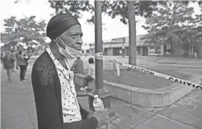  ??  ?? Longtime Kenosha resident Sharon Messey, affectiona­tely known as “Mama Soul” by many in the community, watches firefighters and cleanup crews at businesses along 22nd Avene that were vandalized overnight. “I think this is disgracefu­l. This is our neighborho­od. This is where we shop. This didn’t have to happen here. They didn’t do nothing to us,” she said Tuesday.