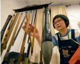  ?? — AFP ?? This file picture shows Taiwan presidenti­al calligraph­er Yang Shu- wan picking a writing brush for her calligraph­y in Taipei.