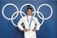  ?? NATACHA PISARENKO/AP PHOTO ?? Simone Biles poses wearing her bronze medal from the balance beam competitio­n during artistic gymnastics at the 2020 Summer Olympics, Aug. 3, 2021, in Tokyo.