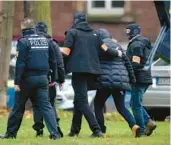  ?? MICHAEL PROBST/AP ?? German police bring in a suspect, second from right, for questionin­g Wednesday in Karlsruhe, a city of 300,000 about 50 miles northwest of Stuttgart.