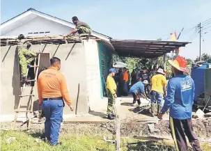  ??  ?? KERJASAMA: Anggota RELA serta wakil dari agensi-agensi lain membantu membaik pulih rumah salah seorang anggota di Kampung Sungai Belian, Lundu.
