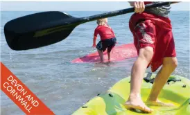  ??  ?? South West is made for seaside fun: Junior paddle boards off a Cornish beach