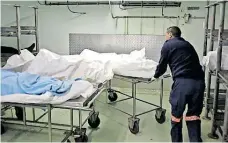  ?? WILLEM LAW ?? A BODY being wheeled to cold storage at the Salt River Mortuary. |
