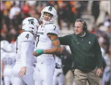  ?? The Associated Press ?? SPARTY SPOILER: Michigan State head coach Mark Dantonio, right, congratula­tes Matt Coghlin (4) and Cody White (7) Saturday after a successful field goal against Maryland in the first half of 24-3 win by the Spartans in College Park, Md.