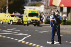  ?? Alex Burton / New Zealand Herald ?? A police officer patrols outside the supermarke­t in Auckland where an extremist inspired by the Islamic State group stabbed at least six people.