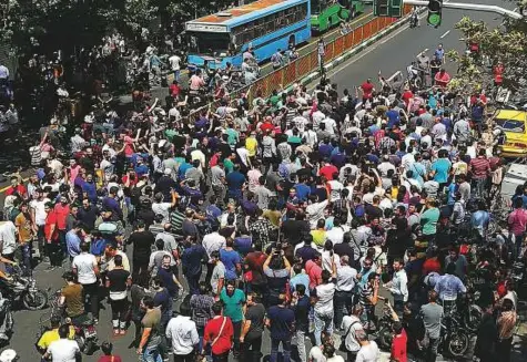  ?? AFP ?? Protesters gather at the mobile market in Tehran on Monday. They shouted slogans and threw rocks in the streets, before being dispersed by anti-riot police. Shopkeeper­s were on strike in other cities, including Arak, Shiraz and Kermanshah.